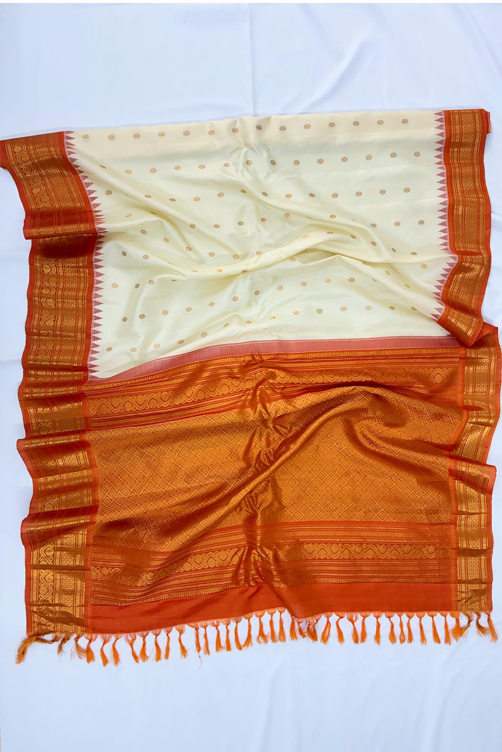 gadwal Cream half white shade butas, orange border handloom silk saree